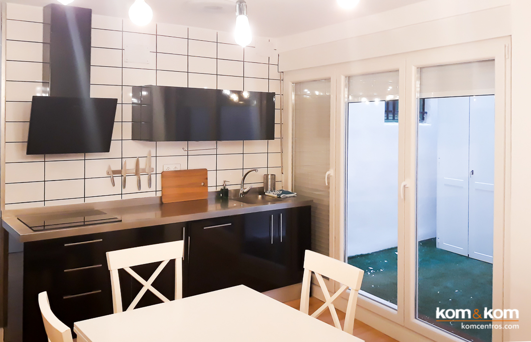 cocina peque&ntilde;a negro brillante, encimera inox, blanco mate